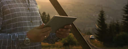 Male's hands holding digital table outdoorの写真素材