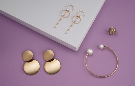 Top view of modern jewelries collection on white podium on purple background with copy spaceの写真素材