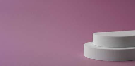Panorama of white round double story podium on pink background with copy spaceの写真素材