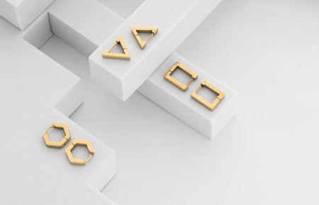 Top view of golden geometric earrings on white background with copy spaceの写真素材