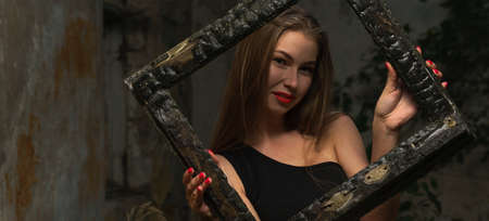 Panoramic shot of a woman looking through grunge burned frameの写真素材