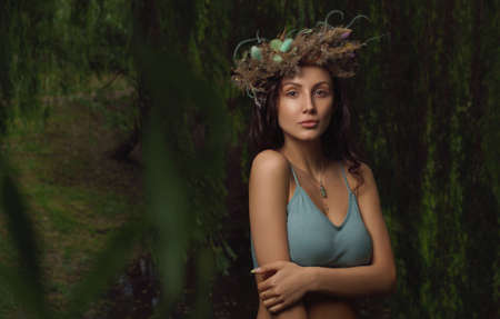 Pretty woman wearing laurel wreath in the forest with copy spaceの写真素材