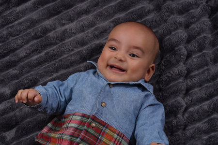Cute baby boy wearing jeans shirt laughing