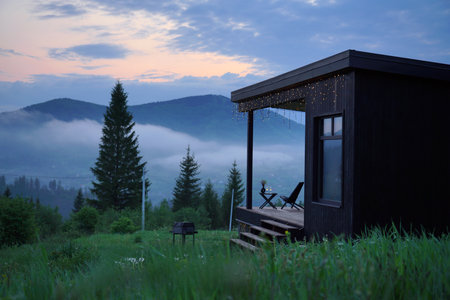 black wooden cabin with foggy mountain view evening at blue hourの写真素材