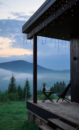 wooden chair and table on terrace with foggy mountain view evening on blue hourの写真素材