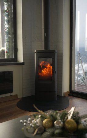 Modern fireplace in a cozy house with snowy mountain viewの写真素材