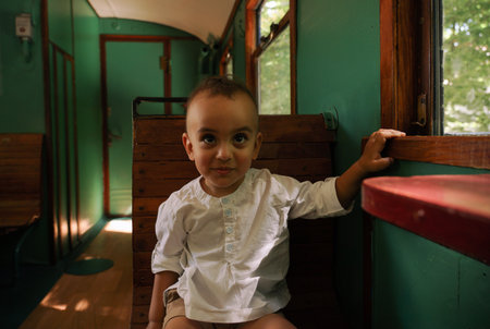 Happy Middle eastern toddler sitting in vintage train with copy spaceの写真素材