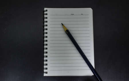 pencil and notebook on isolated black backgroundの写真素材