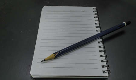 pencil and notebook on isolated black backgroundの写真素材