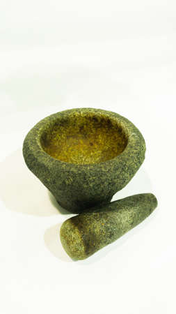 Mortar and pestles or lesung batu in Malay on a isolated white background. An ancient or traditional tool to prepare ingredients or substances by crushing and grinding them into a fine paste or powderの写真素材
