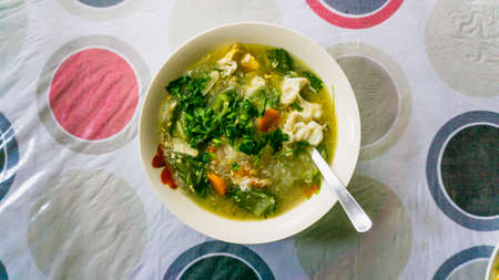 The flat lay of the mixed vegetables soup with soo hoon noodles in a bowl. Carrot, cabbage, broccoli and boiled egg mix together. Good diet foods. Easy homemade menu. Image is a bit out of focus.の写真素材