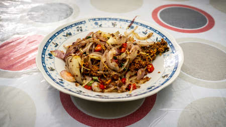 Fermented fried freshwater bream fish with fried onion or ikan pekasam in a plate on table. A traditional food in Malaysia. Marinade the fish in salt and covered it with rice powder for several weeks.の写真素材