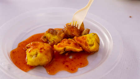 Cucur Udang or Prawn Fritters covered with chilli sauce on isolated white background,it's a common...