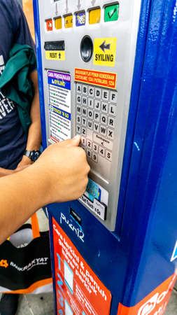 Bangsar, Malaysia - October 28, 2019: Unidentified man using the parking ticket payment machine at...