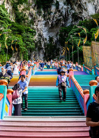Gombak, Malaysia - January 4, 2020: Crowd of local people and tourist climbing the beautiful and colorful stairs to reach to the Famous and Iconic limestone Batu Caves in Selangorのeditorial素材