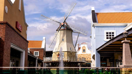 Alor Gajah, Melaka - June 6, 2019 : An old windmill house with the clear blue sky and water fountain...