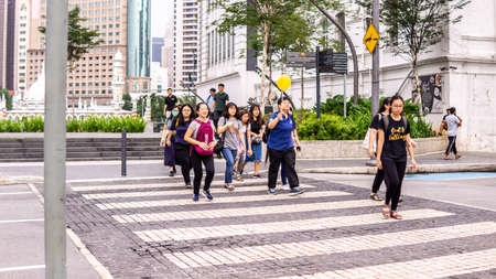Pedestrian crossing the road on the zebra line at the Kuala Lumpur street during the day.のeditorial素材