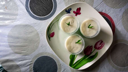 Close up of Som Som Sagu or Sagu Gula Aanau with pandan leaf on a flower plate on table, a Malaysia sweet dessert made of sago, rice flour and anau sugar.の写真素材