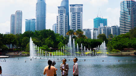 Kuala Lumpur, Malaysia - July 30, 2019: Unidentified tourist at KLCC Park with a water fountain show...
