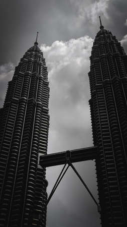 Kuala Lumpur, Malaysia - July 30, 2019: The black and white low angle view of the Petronas Twin Towers or KLCC in the city. Dark color concept.のeditorial素材