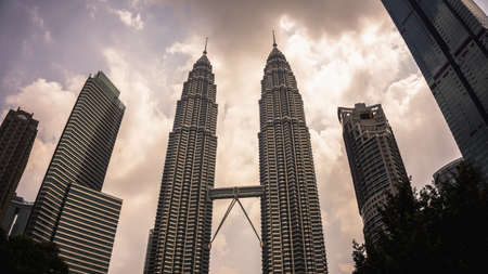 Kuala Lumpur, Malaysia - July 30, 2019: The low angle view of the Petronas Twin Towers or KLCC in the city during the evening.のeditorial素材