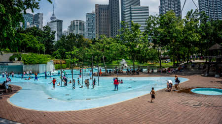 Kuala Lumpur, Malaysia - July 30, 2019: The view of the crowd of peoples at the KLCC Park Swimming Pool in Kuala Lumpur during the holidays.のeditorial素材