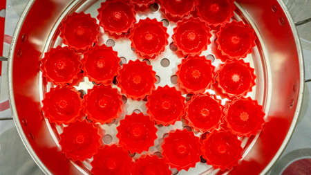 Close up view of red food mold for bakery in steamer case before baking at the kitchen. Floral shape...