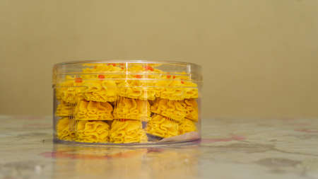 Side view of Kuih Semperit Dahlia, a traditional Malaysian Scottish butter cookies in a round box usually found during Eid al-Fitr celebration. Selective focus.の写真素材