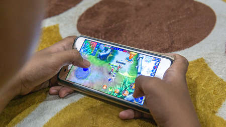 Selangor, Malaysia - July 9, 2019: The top view of people playing famous mobile games called Mobile...