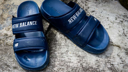 Talang, Negeri Sembilan - July 31, 2020: Close up view a pair of blue New Balance flip flops with vintage background.のeditorial素材