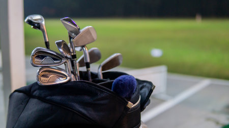 The close up view of the various type of golf club in the stand beg at the golf driving range during the night. Noise photo because of the light exposure.の素材 [FY310170327364]