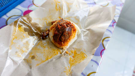 Cheap street Nasi lemak with squid cutlet sambal on brown food packaging. Malaysian traditional...