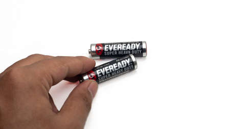 Sungai Buloh, Malaysia - December 11, 2020: Hand holding piece of Eveready Super Heavy Duty AA isolated on white background. Energizer Holdings is an American manufacturer of batteries.のeditorial素材