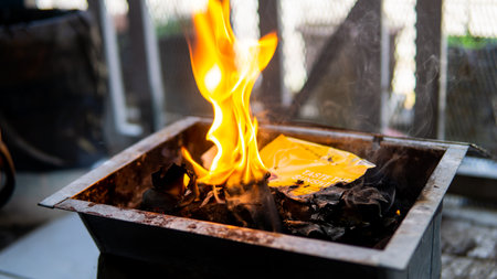 Flaming charcoal briquettes on mini grill box with open fire, barbeque party preparation. Selective focus.の写真素材