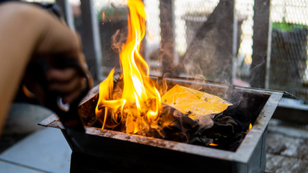 Flaming charcoal briquettes on mini grill box with open fire, barbeque party preparation. Selective...