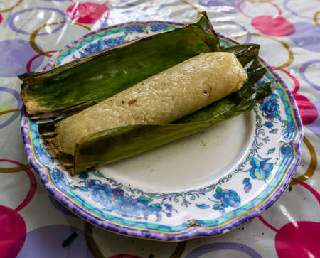 Pulut Panggang, a Malay traditional dessert on plate grilled glutinous rice wrapped in banana leaf stuffed with savory fillings.の写真素材