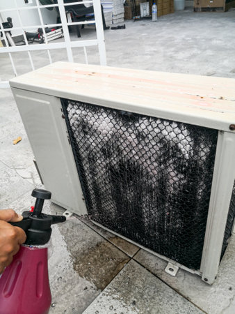A technician spraying a chemical substance on air conditioner compressor using water dispenser pump. Overhaul cleaning service .の写真素材