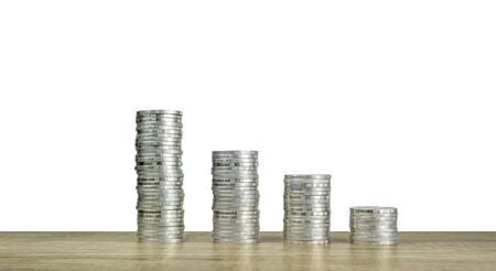 A row of money silver coin stacks on wooden table and white background