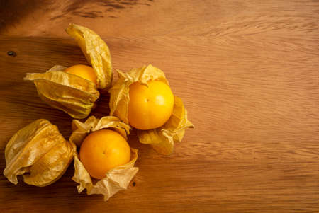 Yellow ripe Cape gooseberry fruit in a brown wooden background know as goldenberry or physalis, top view imageの写真素材