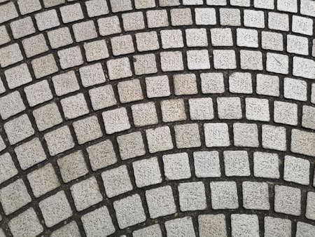 Top view, curve pattern of grey cobblestones paving on a street