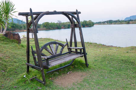 Wooden bench on side of Lake,Thailandの写真素材