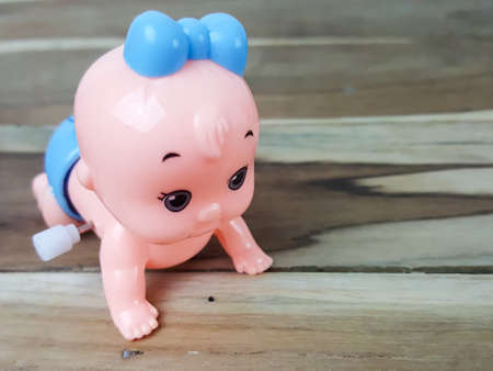 Mechanical wind up crawling baby toy on wood backgroundの写真素材