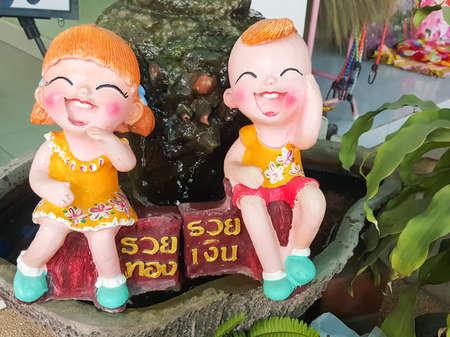 close up,Happy dolls for garden decoration havegreeting in Thail means that the rich silver-rich goldの写真素材
