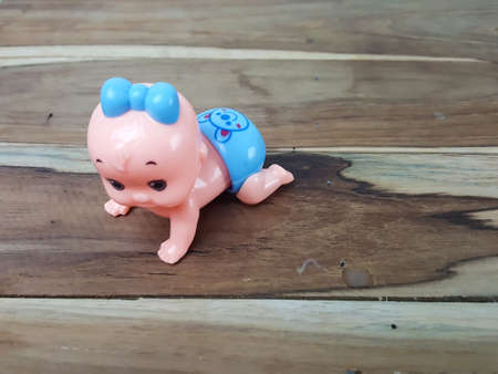 Mechanical wind up crawling baby toy on wood backgroundの写真素材