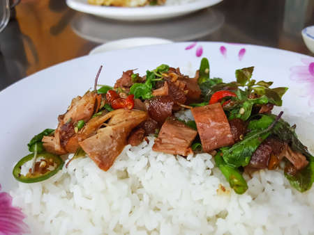 Close-up,Thai food style:Pad Kra Pao Kha Moo, spicy stir-fried pork leg with Thai/Holy basil ,chili serve with riceの写真素材