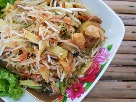 close-up,Thai food style:green papaya spicy salad Thai style on bamboo background