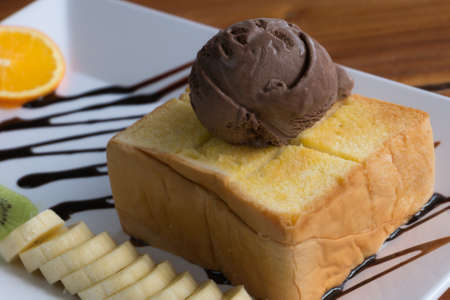 Honey Toast bread topped with ice cream, chocolate sevred with fruit and whipped cream,process colorの写真素材