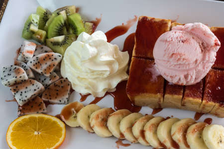 Strawberry honey Toast bread topped with ice cream, stawberry sevred with fruit and whipped cream,process colorの写真素材