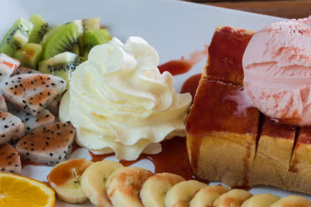 Strawberry honey Toast bread topped with ice cream, stawberry sevred with fruit and whipped cream,process colorの写真素材