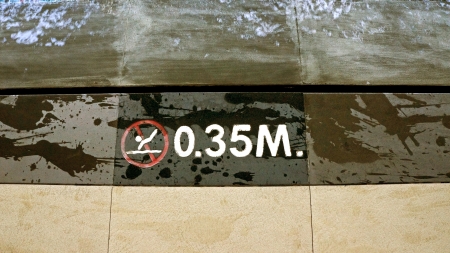 Sign showing 3.5 ft depth on edge of blue swimming pool with no divingの写真素材